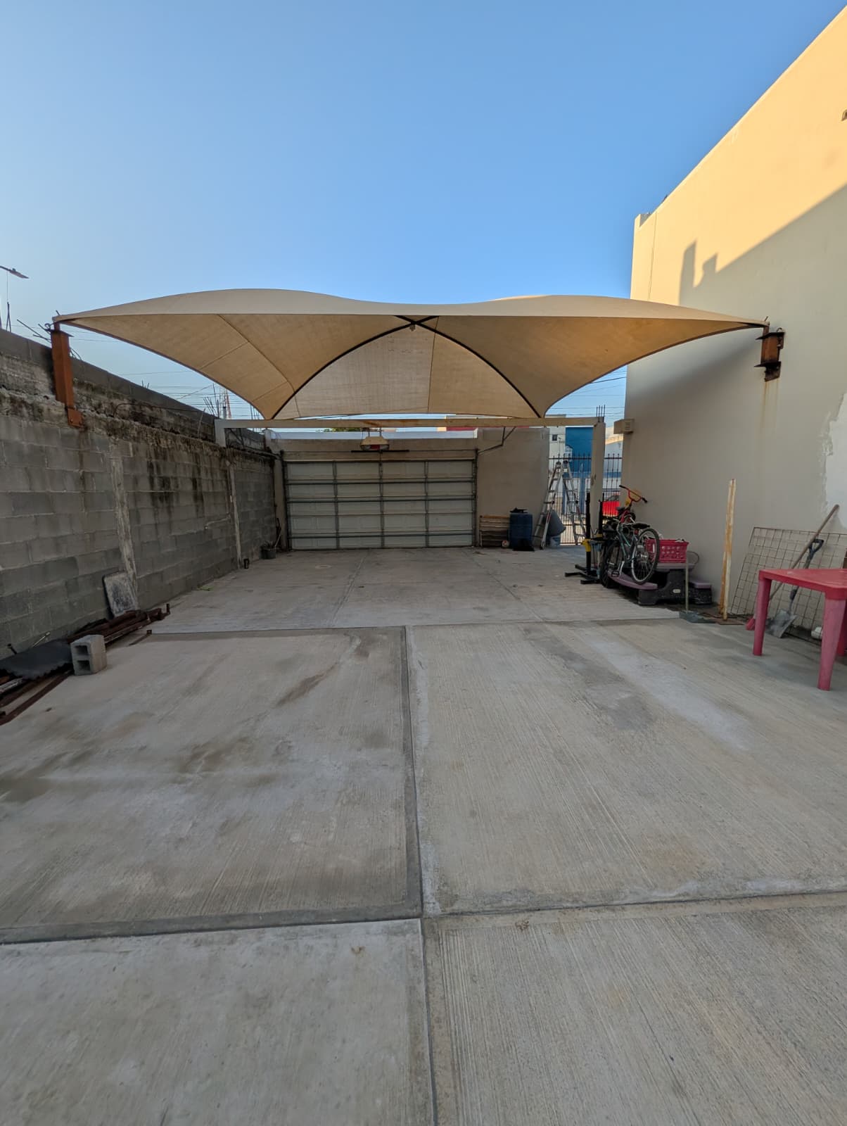 Toldo de lona color beige instalado en cochera