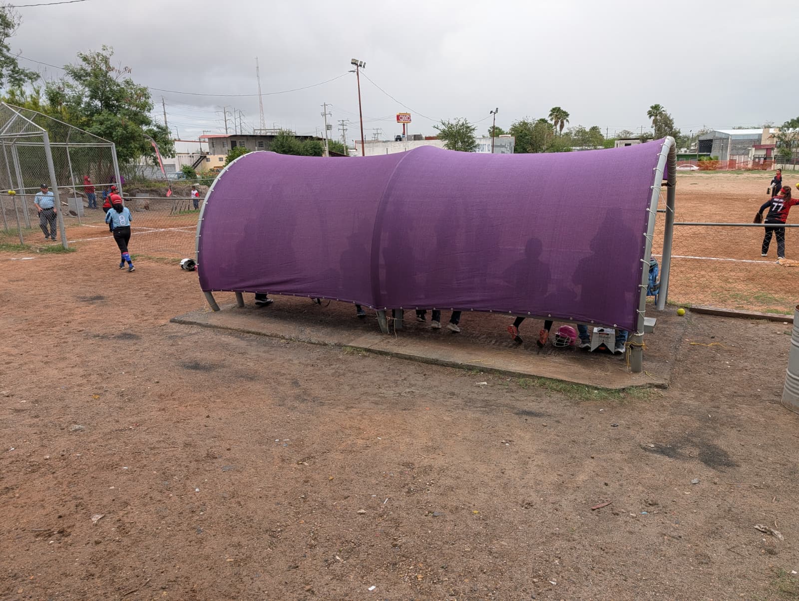 Estructura semicilíndrica morada en campo de softbol